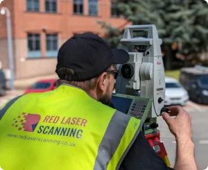 A surveyor operating a total station for precise land measurement on a construction site