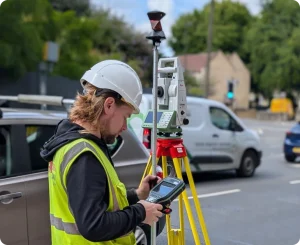 Our expert uses a total station for a roadside topographic survey, ensuring precise mapping of site features and building layouts