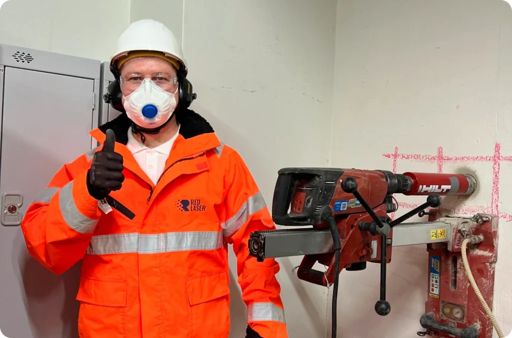 Red Laser technician providing core drilling service using mounted equipment